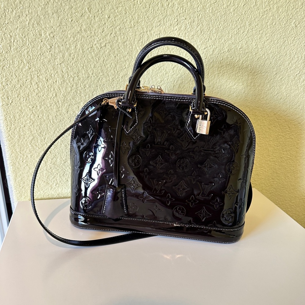 LOUIS VUITTON
Alma PM Monogram Vernis Leather Satchel Bag Amarante